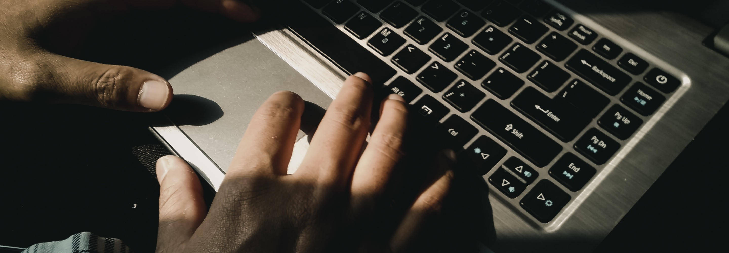 Photo of hands typing on a laptop; Photo by Yudi Indrawan on Unsplash