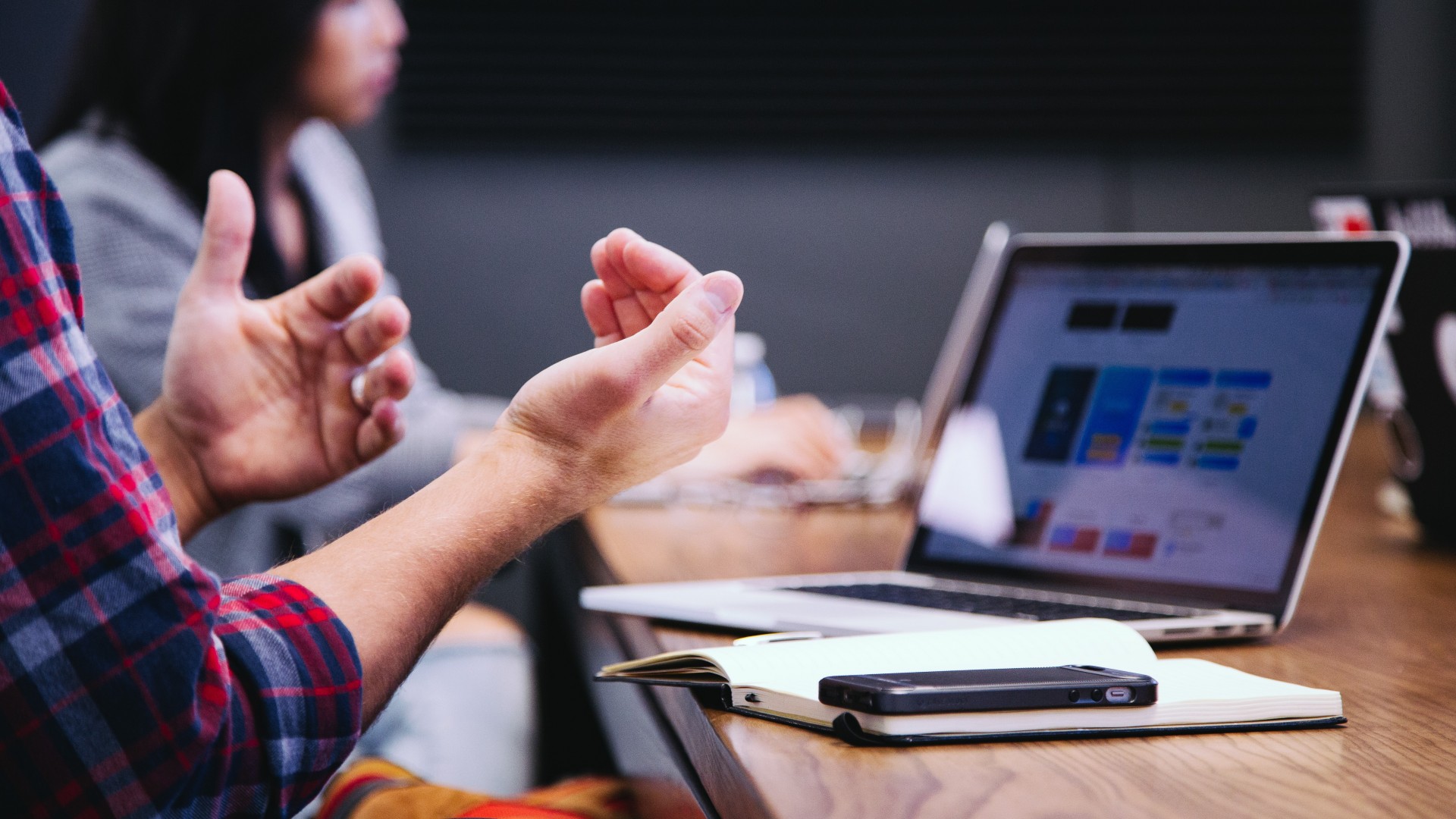 Two people talking at a table in an office setting; Photo by Headway on Unsplash