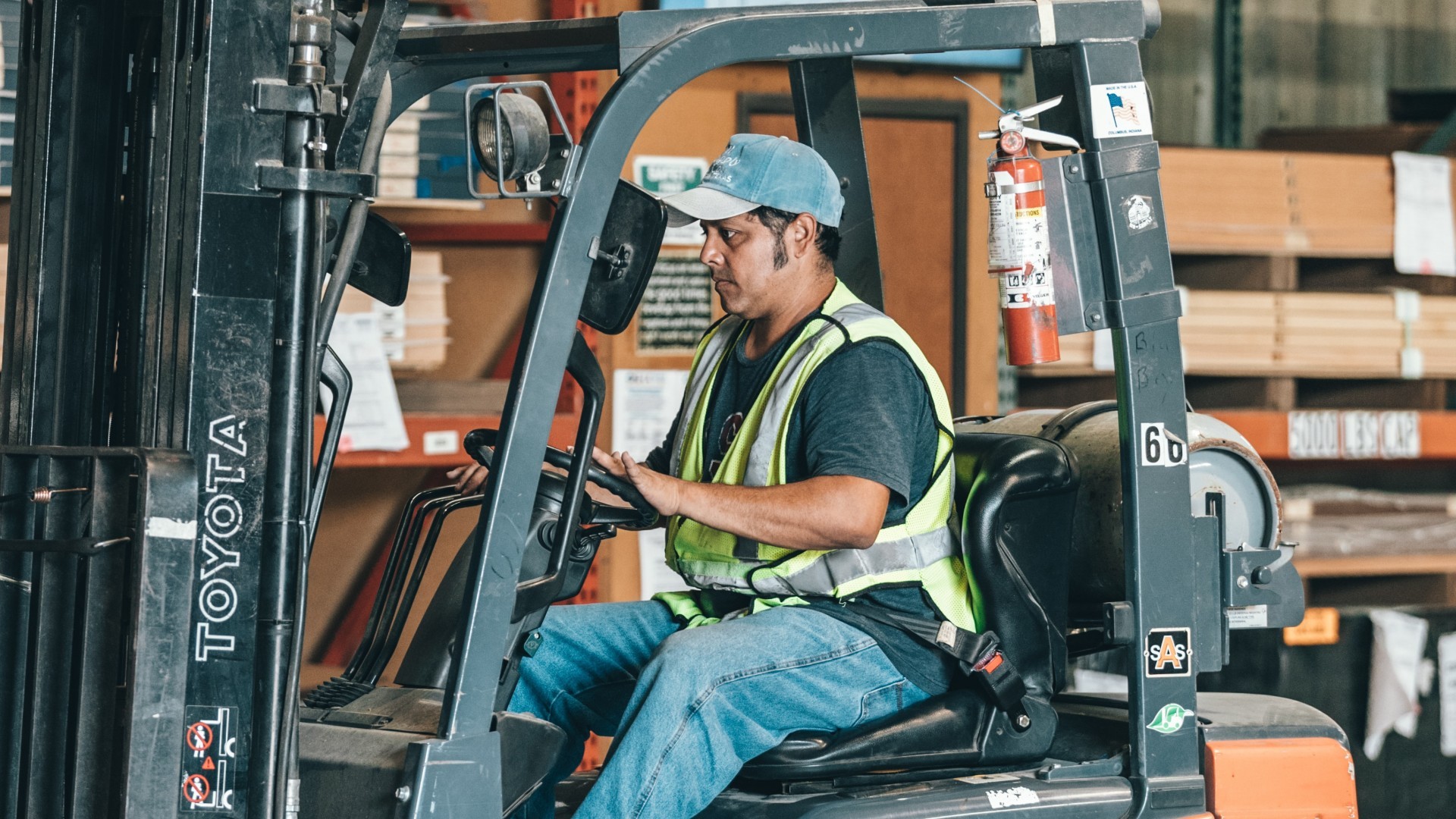 A man drives a forklift inside a warehouse