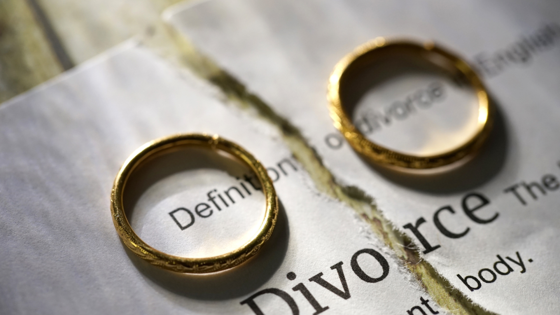 two wedding rings sit on top of a divorce petition
