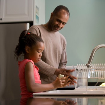 An adult and child washing their hands in the kitchen; Photo by CDC on Unsplash