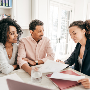 A man and a woman sit and meet with another woman who is a lawyer