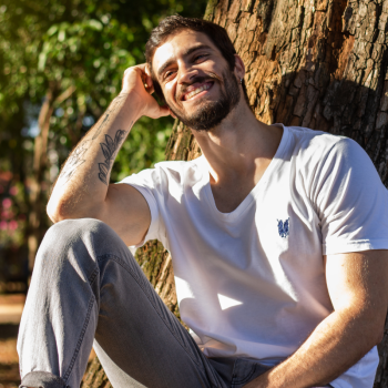 a man sits under a tree and smiles
